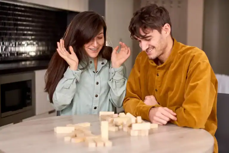 Couple playing Jenga game for fun and bonding at home.