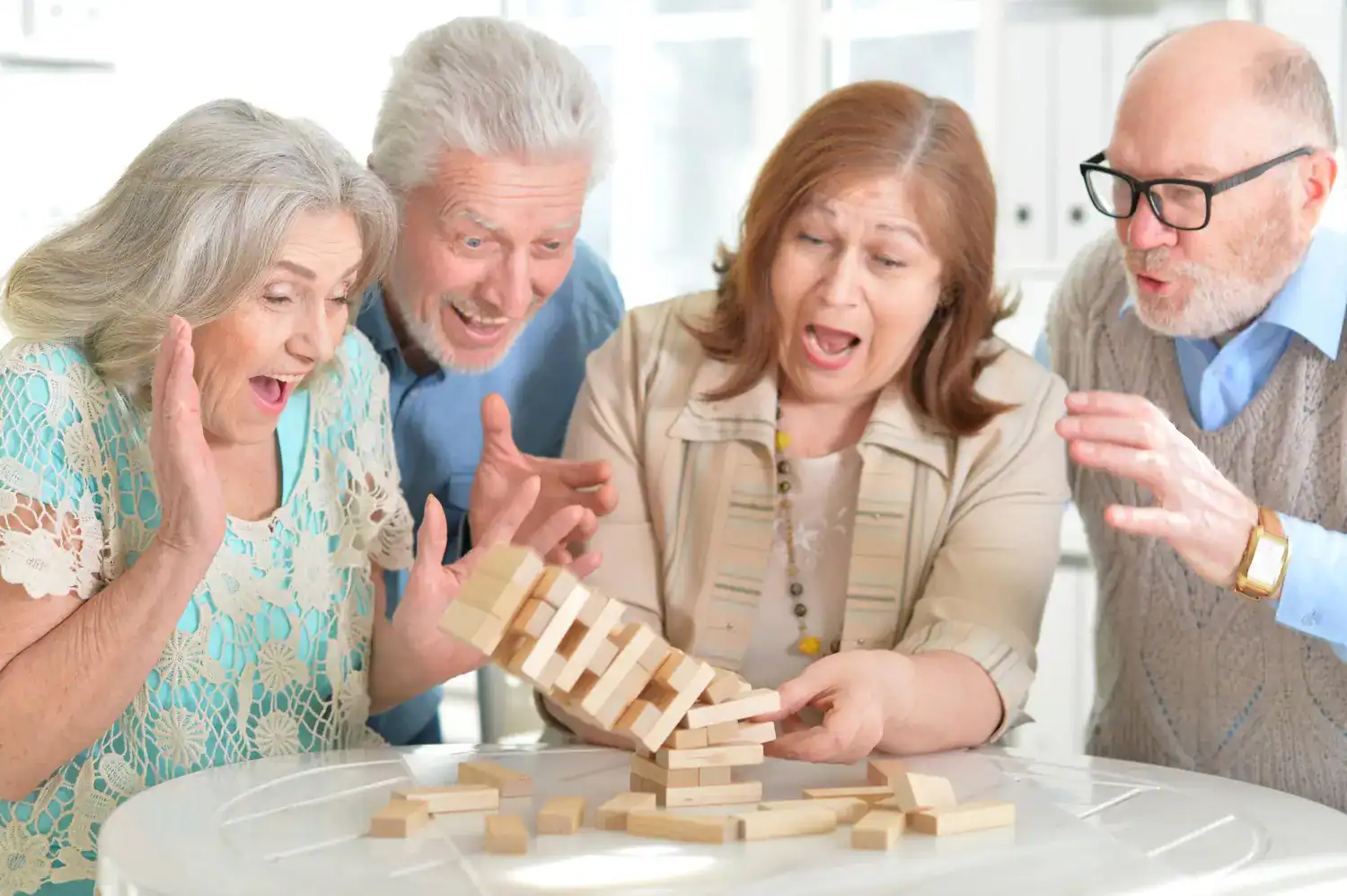 Senior citizens enjoying a lively game of giant Jenga at a celebration.