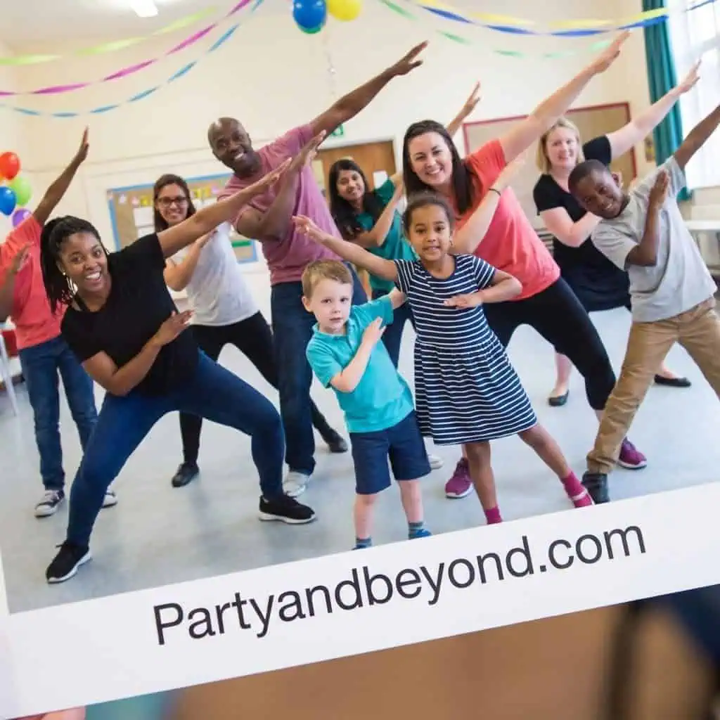 Group of adults and children enjoying a dance party at a social event.