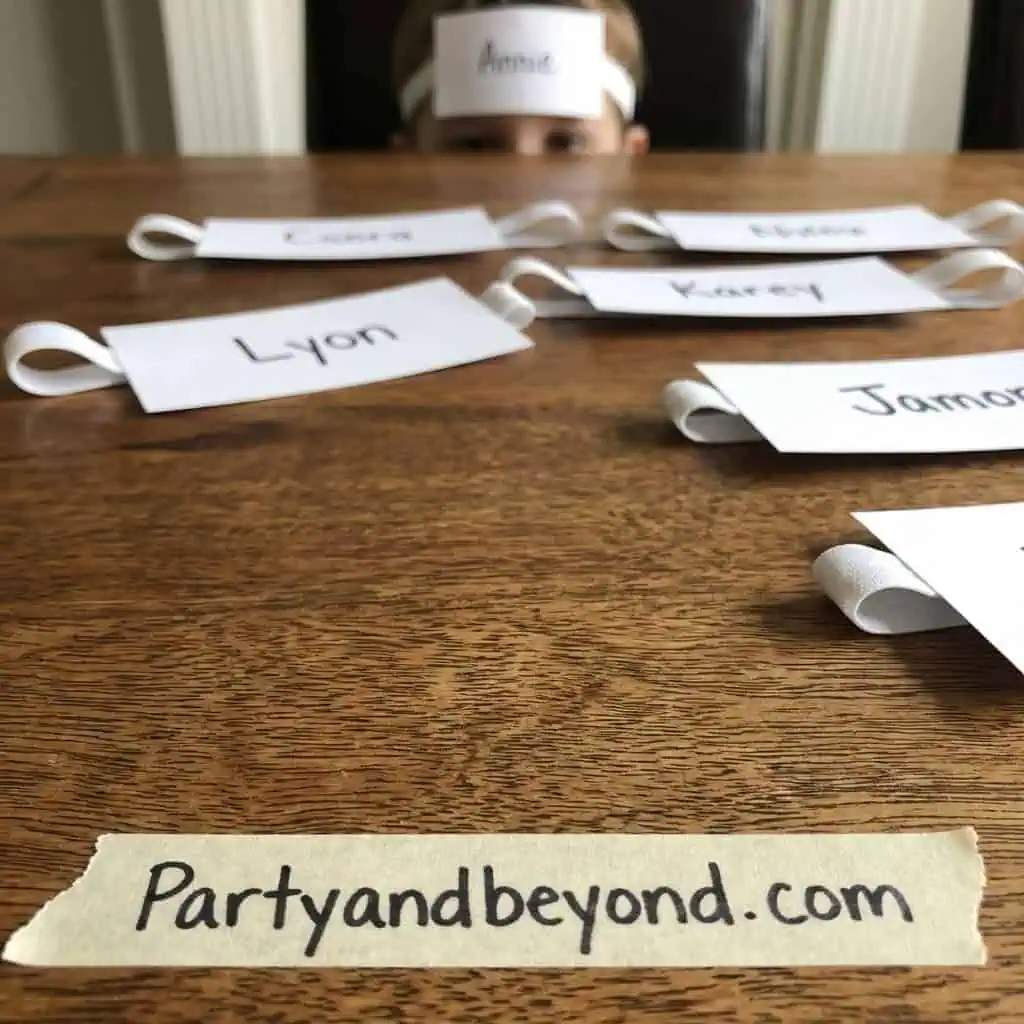 Name tags for dinner party games on a wooden table.
