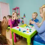 29 Entertaining Minute to Win It Classroom Games Children playing classroom game with colorful toys and friends.