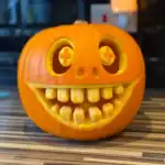 41 Unique Pumpkin Carving Ideas for a Standout Display Pumpkin with a wide, smiling face and quirky eyes, perfect for festive Halloween decorations.