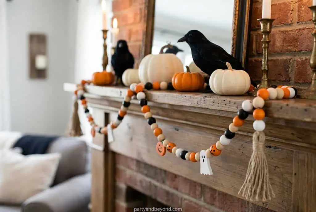 Halloween wood bead garland in black orange and white draped across a mantel