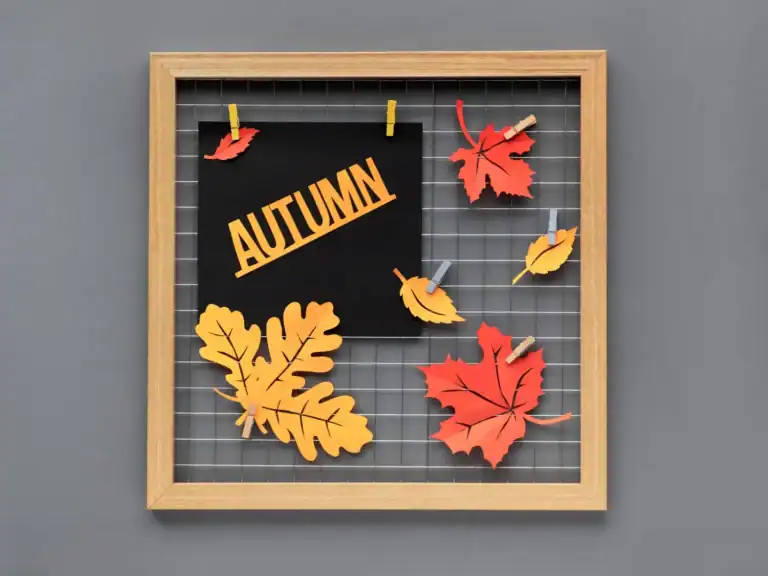 Fall leaf craft display with paper leaves on a wire grid for autumn decoration.
