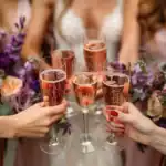 17 Unique and Interactive Bridal Shower Game Ideas Women clinking champagne glasses at bridal shower celebration.