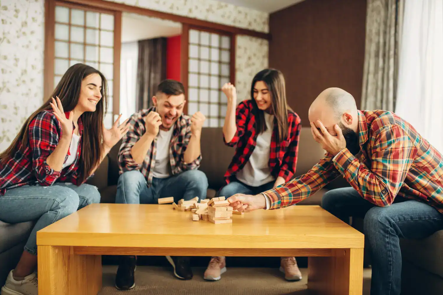 Group of friends playing Jenga at a college party, having fun and enjoying games.