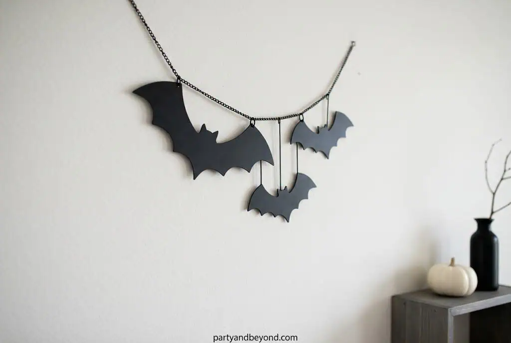 Matte black wooden bats mounted on a dark walnut stained wood plank for Halloween wall decor