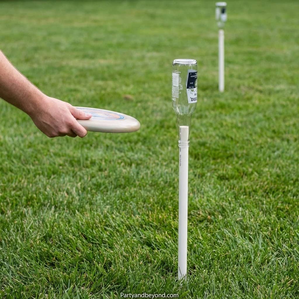 Disc golf game with water bottle target on grassy field.