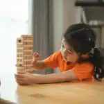 41 Easy Minute to Win It Games for a Blast at Any Gathering Children playing Jenga game at a party or gathering.