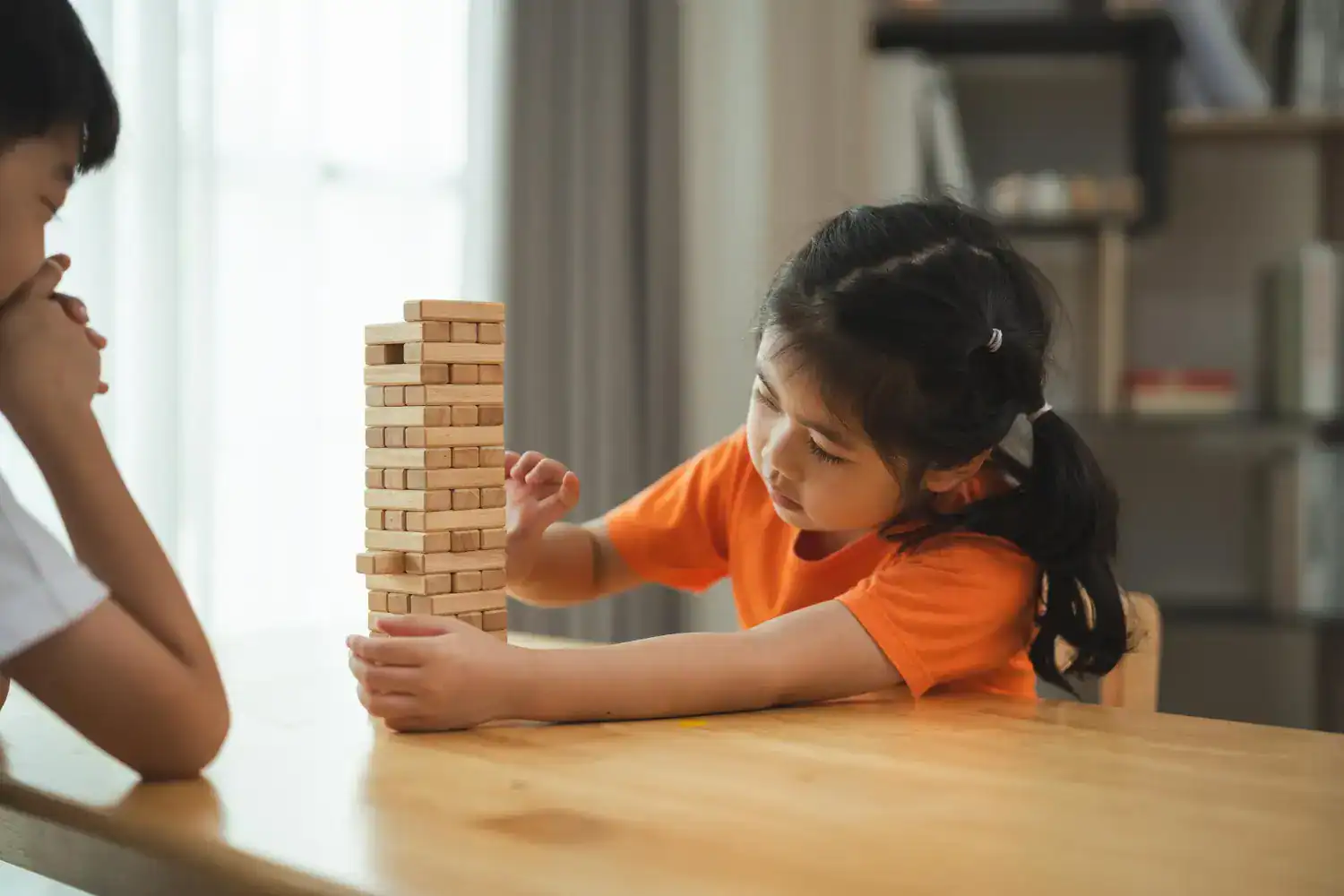 Children playing Jenga game at a party or gathering.