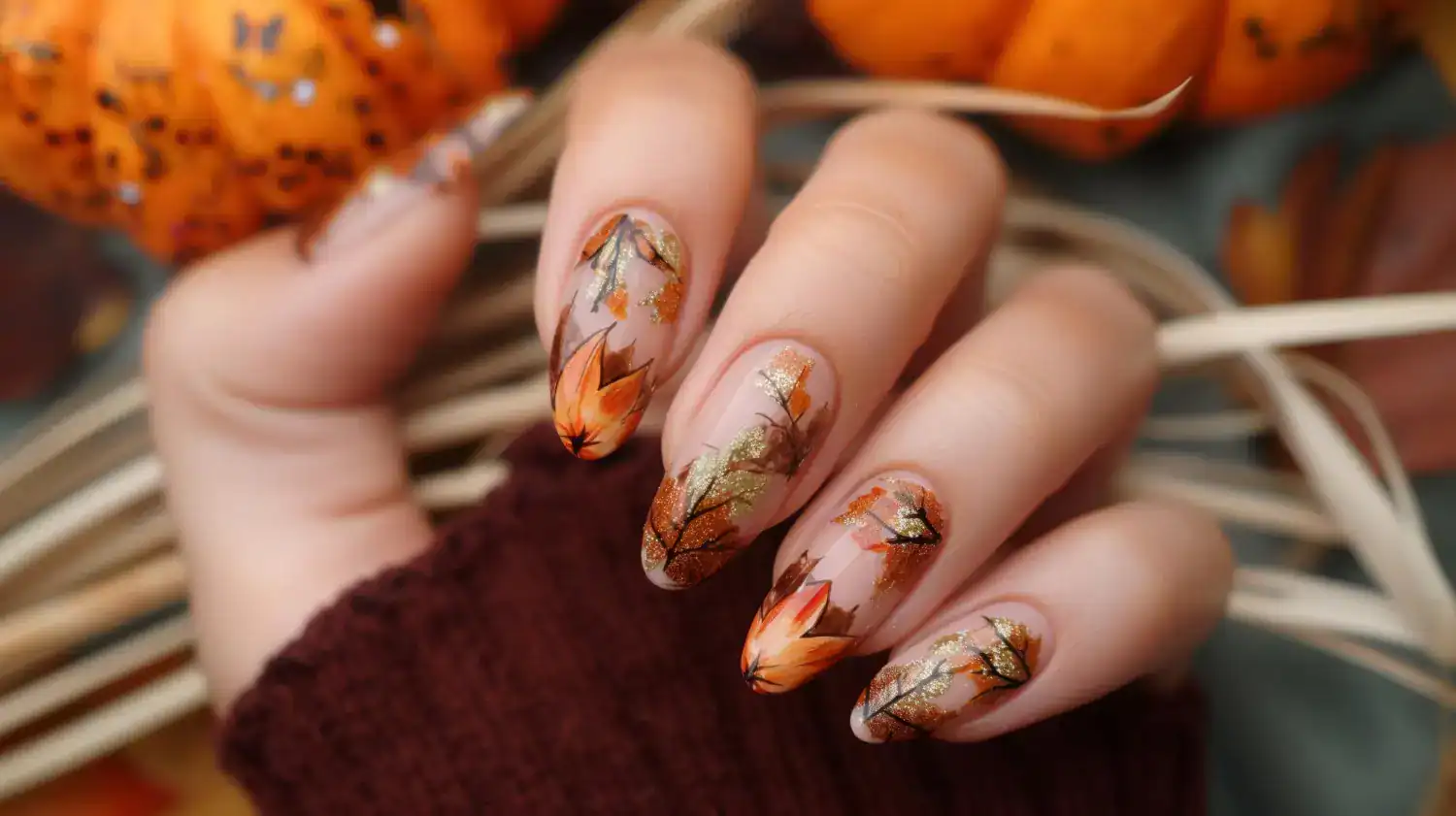 Beautiful fall-inspired nail art with orange and gold accents.