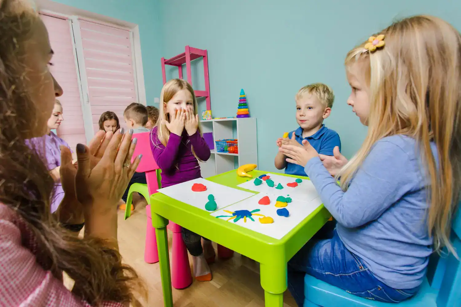 Children playing classroom game with colorful toys and friends.