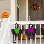 25 DIY Halloween Decoration Ideas (Easy, Cheap & Spooky for 2026) Pumpkin with carved face and hanging skeleton masks for Halloween decor.