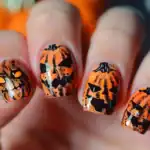 29 Chic Pumpkin Nail Art Ideas for Fall and Halloween Spooky Halloween pumpkin nail art with orange and black designs.