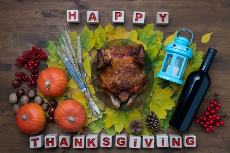 Festive Thanksgiving table with roasted turkey, pumpkins, and autumn decorations for holiday feast.