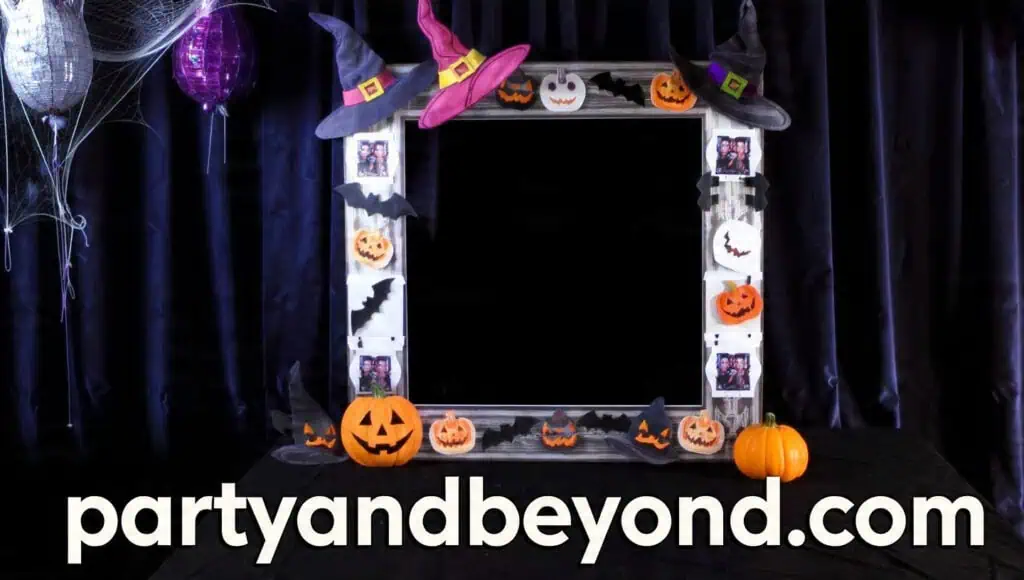 Halloween photo booth with cardboard frame props, hats, and themed accessories Halloween Backdrop Ideas