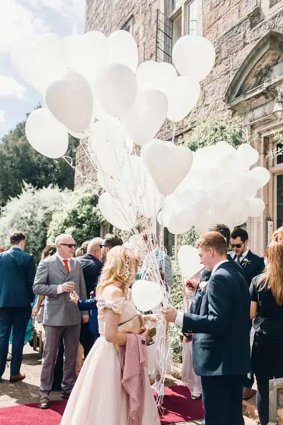 Beautiful wedding entrance decorated with white balloons and bridal party guests.