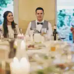 13 Amazing Wedding Reception Food Ideas On A Budget (2026) Elegant wedding reception with guests sipping wine and celebrating.