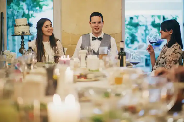Elegant wedding reception with guests sipping wine and celebrating.