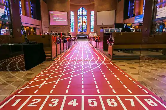Elegant wedding reception entrance with a colorful race track design inside a church.
