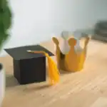 19 Unique Graduation Table Ideas to Make Your Event Stand Out Elegant graduation cap and crown table decor for celebration events.