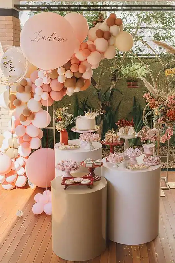 Elegant pink balloon and cake table setup for a stylish birthday celebration.