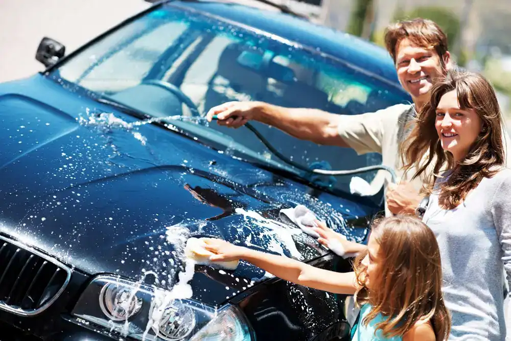 Kids washing a car during a fun outdoor activity.