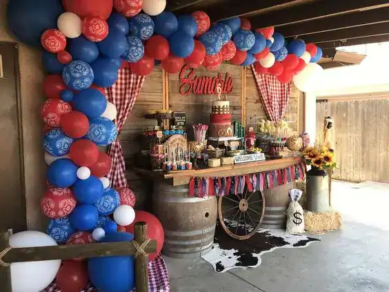 Colorful balloon arch with red, white, and blue balloons framing a festive dessert table.