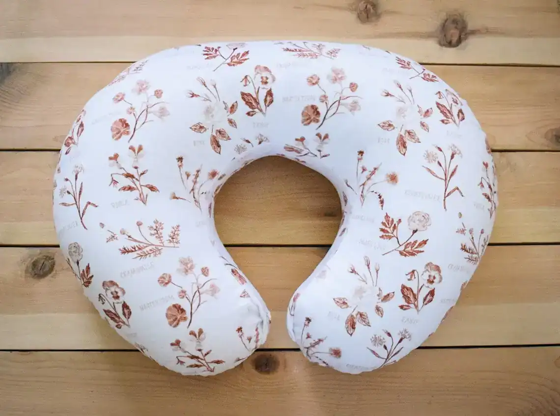 Nursing pillow with a delicate floral pattern, perfect for new moms during baby shower celebrations.