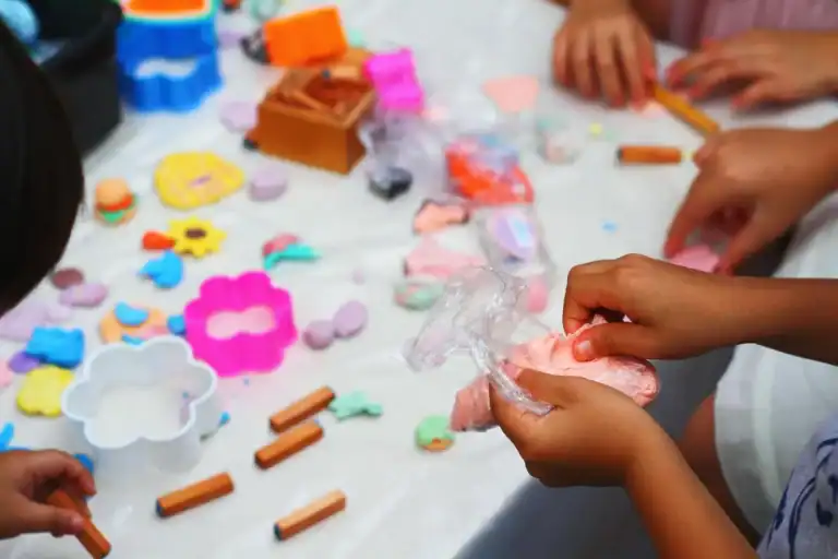 Children engaging in sensory play with clay and textured materials for sensory development.