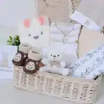 19 Perfect Baby Shower Gift Ideas for New Mom Adorable baby shower gift basket featuring plush toys, cozy socks, and baby clothing for new moms an.