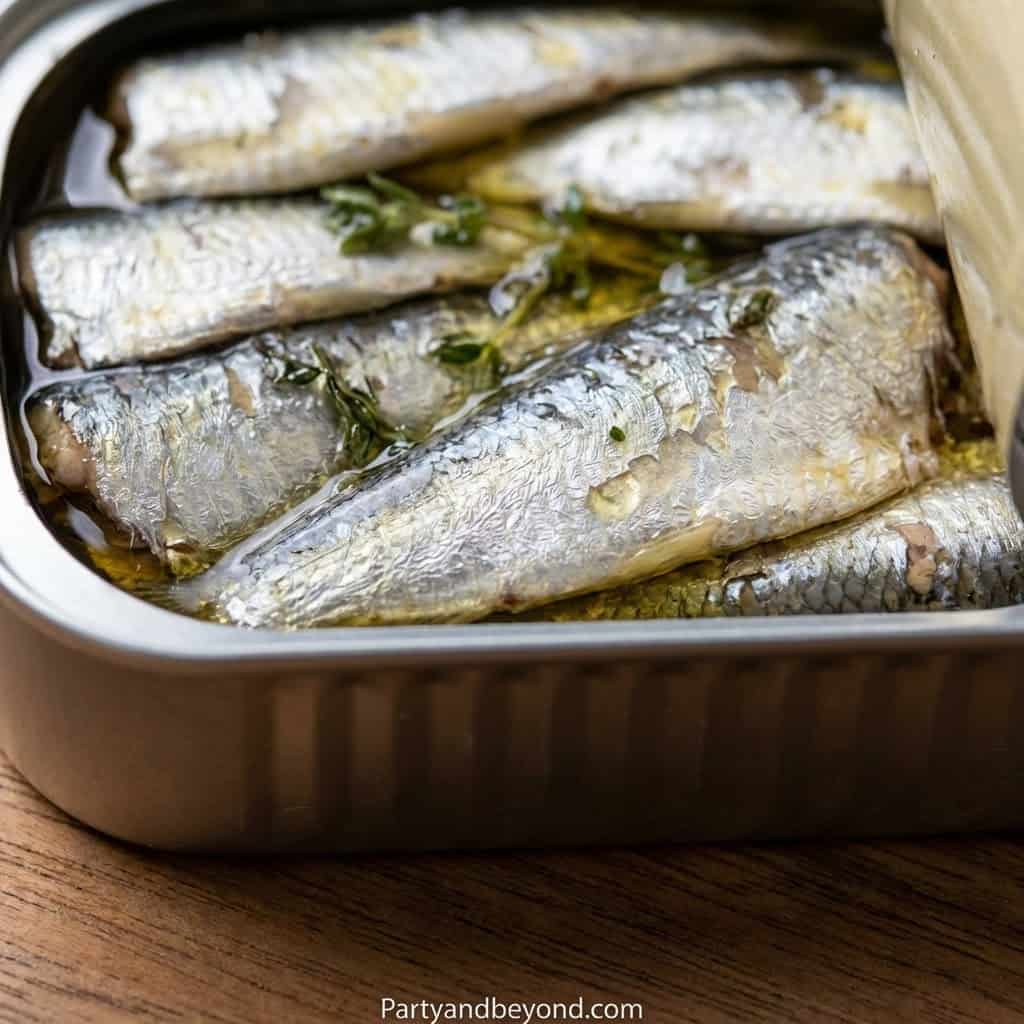 Fresh baked fish fillets with herbs and lemon in a baking dish for a healthy party meal.