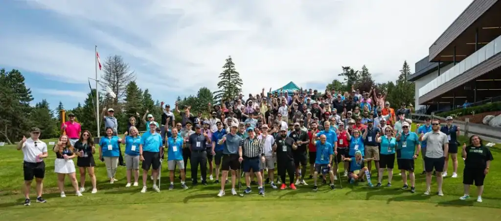 Group of teens and adults participating in a fundraising event outdoors on a grassy field.