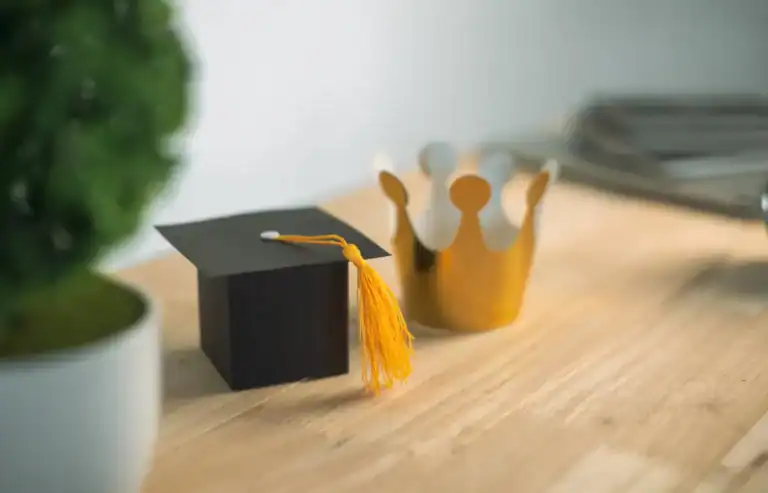 Elegant graduation cap and crown table decor for celebration events.