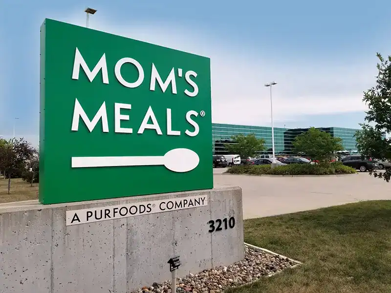 Mom's Meals store sign at a shopping center, ideal for baby shower gifts.