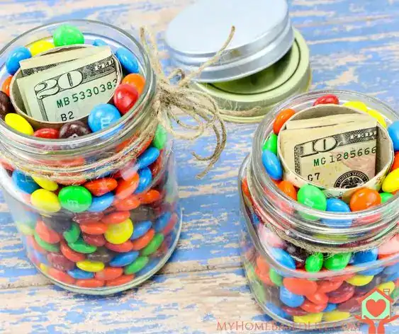 Glass jar layered with colorful candy and dollar bills, a creative money gift idea for teens
