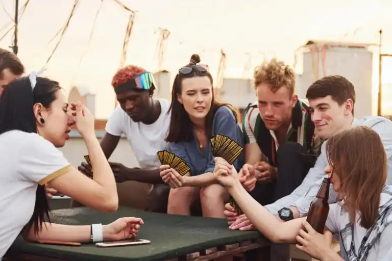 Teenagers playing fun party card game outdoors.
