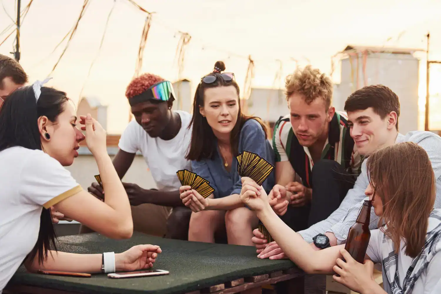 Teenagers playing fun party card game outdoors.