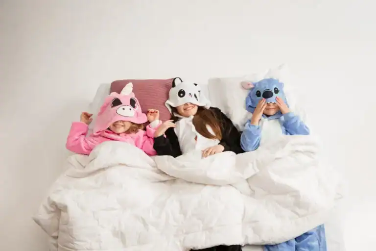 Kids in animal-themed sleepover masks having fun in bed.