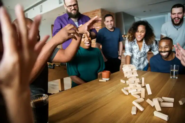 Group of friends playing Jenga at a lively party.