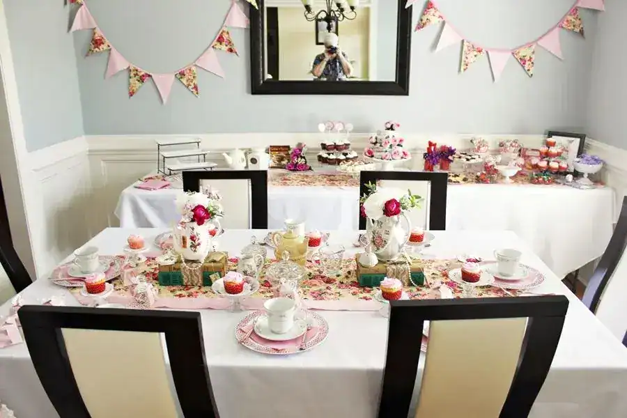 Elegant birthday party table with floral decorations and pastel accents.