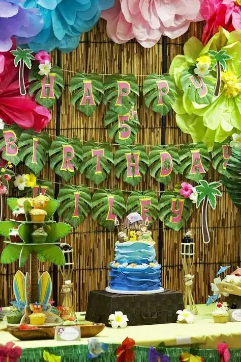 Colorful tropical birthday party decoration with "Happy 5th Birthday" banner.