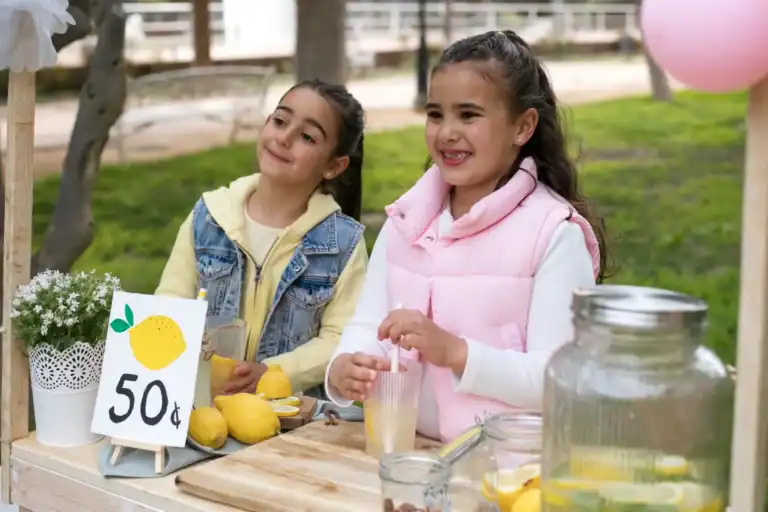 Girls enjoying lemonade stand at a fundraising event.