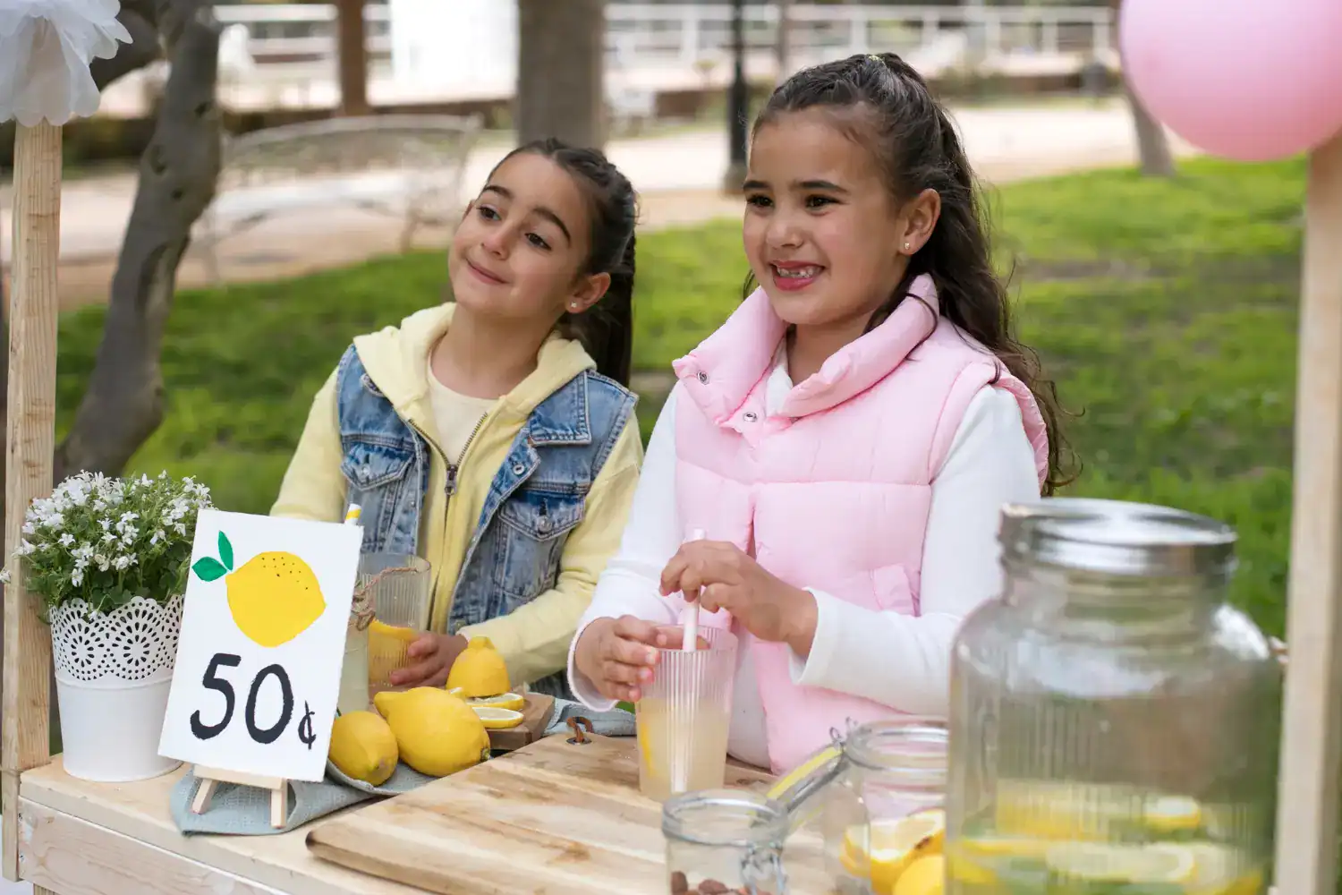 Girls enjoying lemonade stand at a fundraising event.