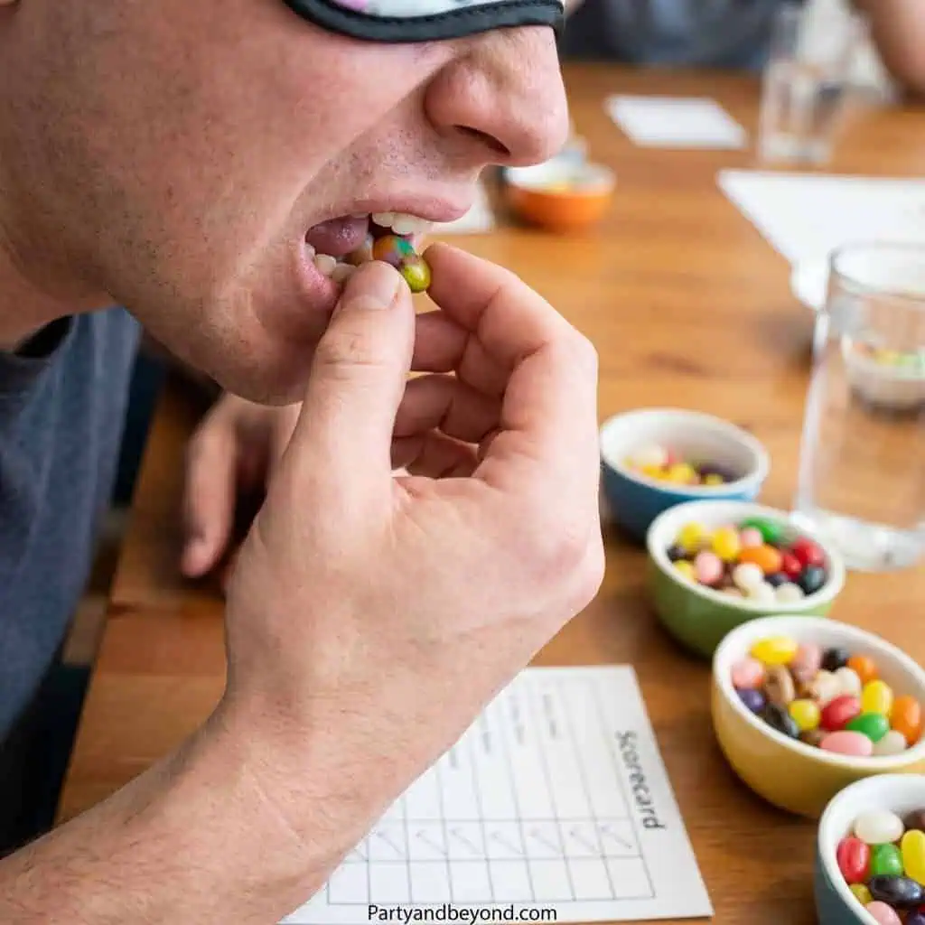 Person eating colorful candies at a fun party game table.