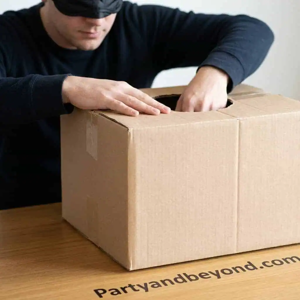 Person opening a cardboard box at a party or event.