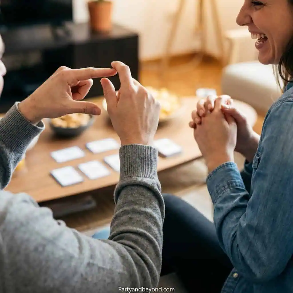 Teenagers playing fun party game with cards at a lively gathering.