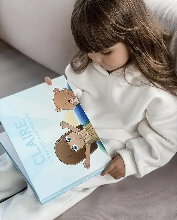 Adorable girl opening a first tooth-themed gift box with cute characters for a child's first birthda.