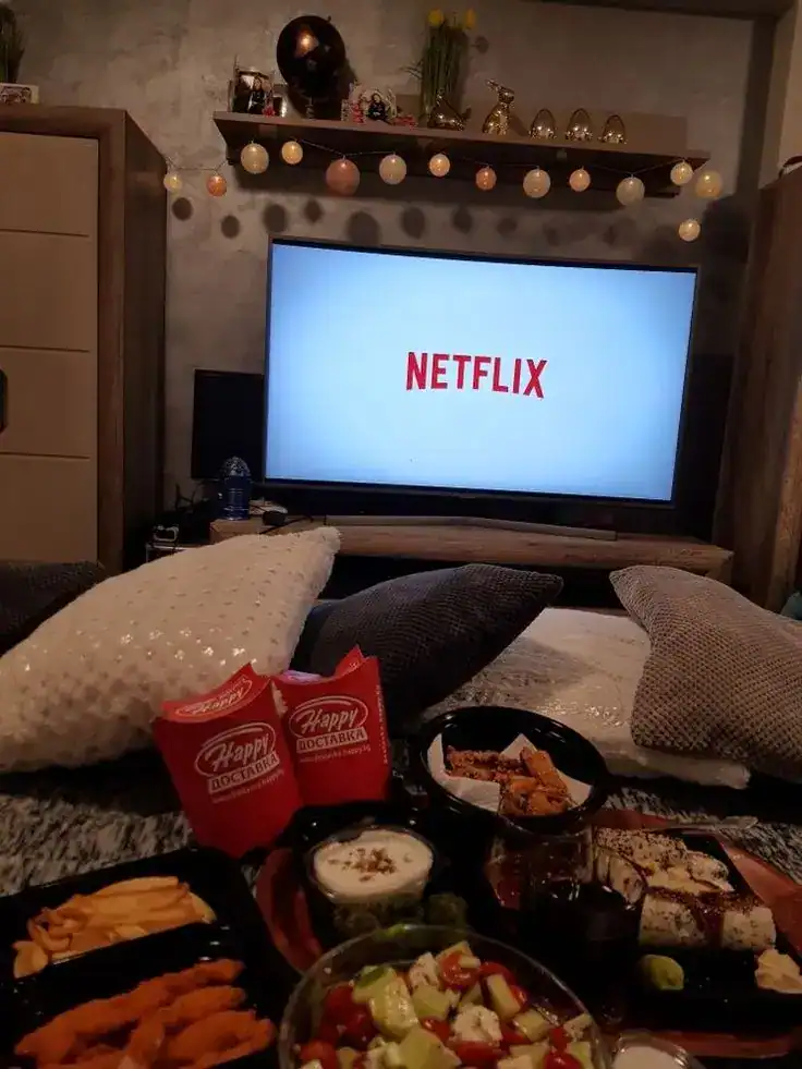 Students in pajamas watching a movie with popcorn and blankets at an end-of-year school pajama party