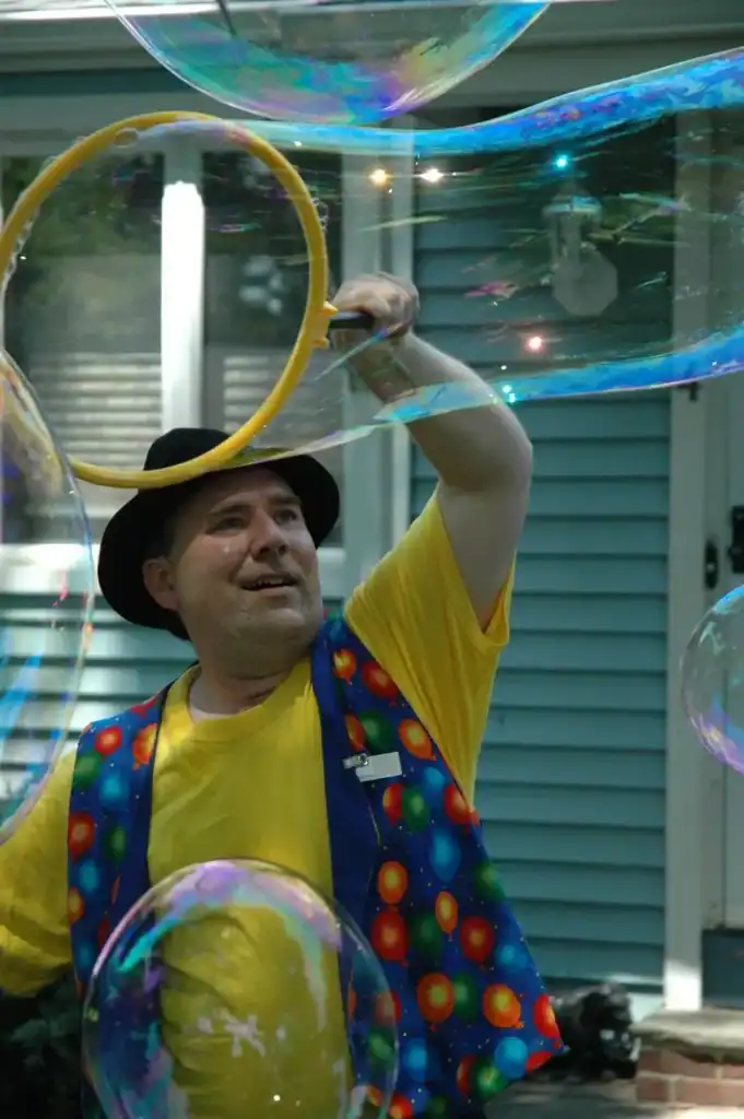 Students making giant bubbles at a bubble bash end-of-year school party outdoors on a sunny day